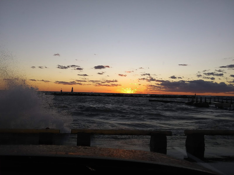 The beaches are a favorite must go to place at sunset.  Here the waves and crashing and splashing at sunset with the North Pier lighthouse in the distance.