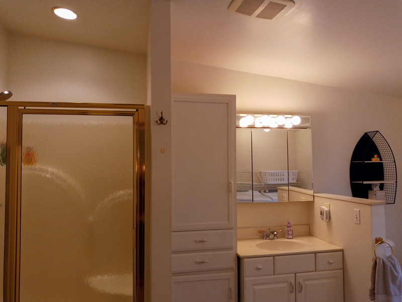 The spacious bright bathroom offers and large shower, lots of storage, and even a washer and dryer.